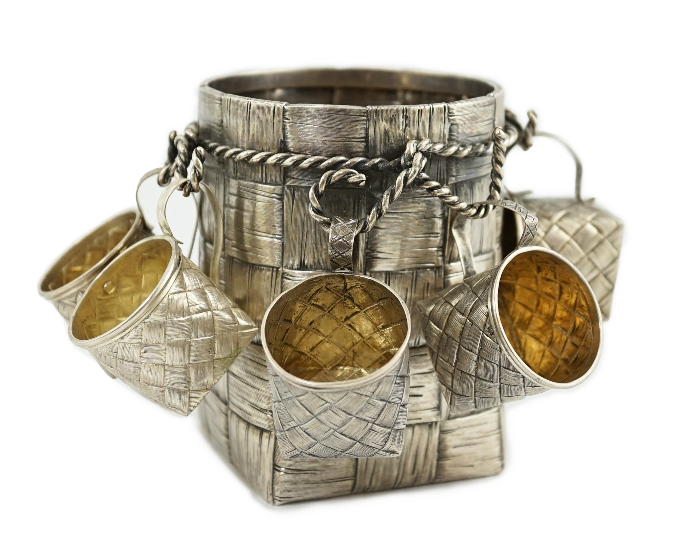 A late 19th century Russian 84 zolotnik silver bottle holder, with basket weave decoration, together with five similar tots